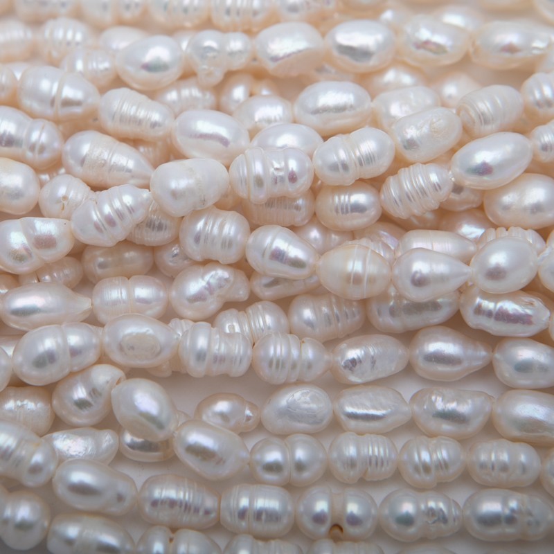 Freshwater pearls / white string 36cm / 7-8mm oval ribbed PASW202
